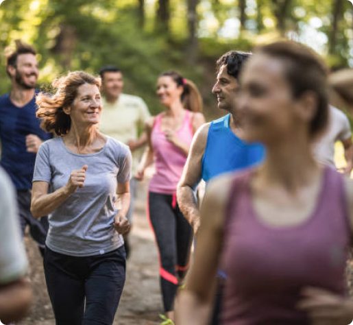 Group of people jogging in a forest, enjoying outdoor exercise and staying fit under the trees.